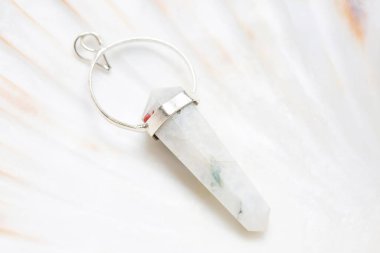 Beyaz kabuk üzerinde metal çerçeve mineral taş kolye