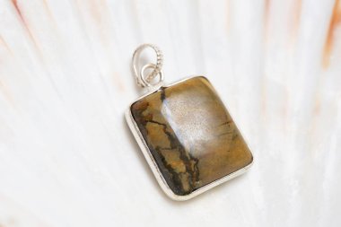 Beyaz kabuk üzerinde metal çerçeve mineral taş kolye