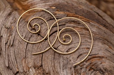 Doğal arkaplanda süslemeli metal küpeler.