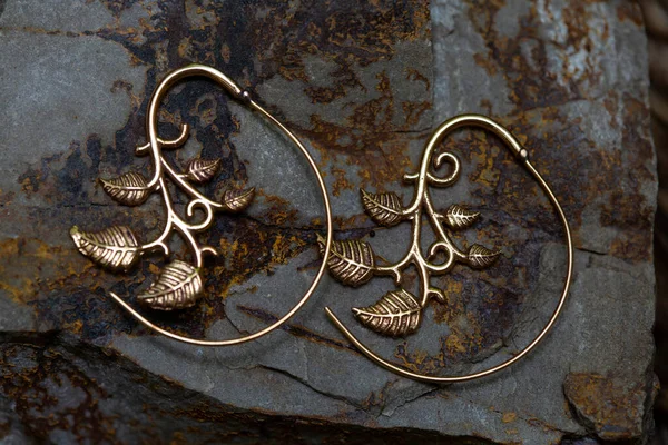 天然背景的装饰黄铜金属耳环 — 图库照片