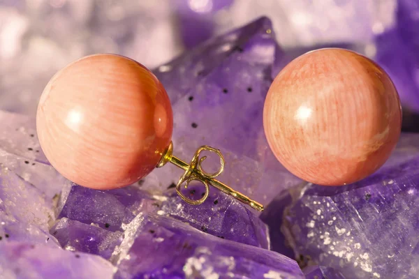 Coral earrings on ametyst background — Stock Photo, Image