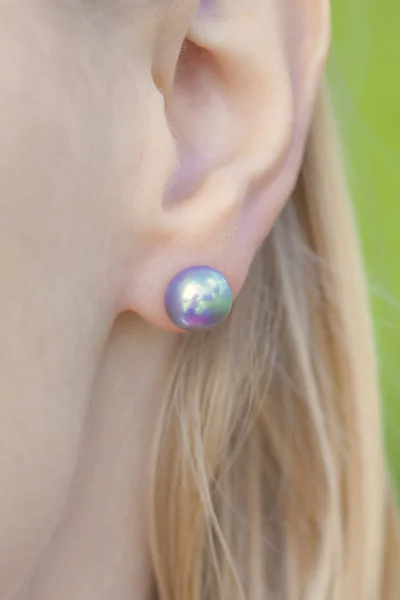 Женское ухо с жемчужной серьгой — стоковое фото