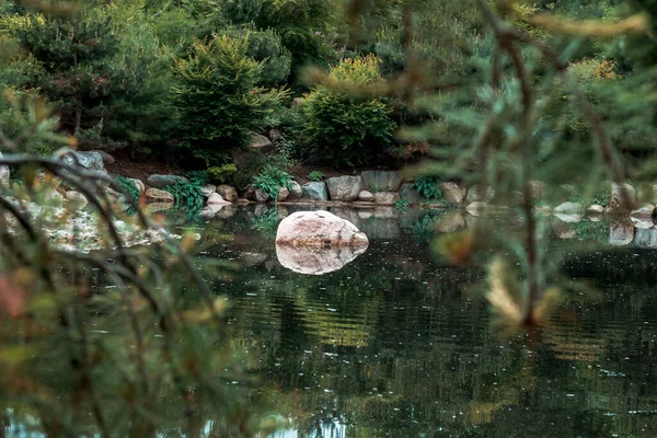 Mirror reflection of a stone on a lake in the japanese garden