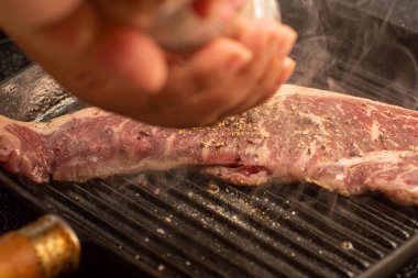 Izgarada tuz ve biberle pişirilmiş biftek.