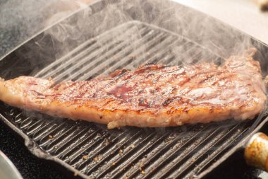 Izgarada tuz ve biberle pişirilmiş biftek.