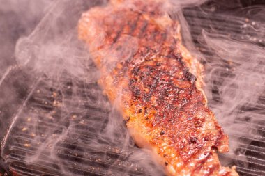 Izgarada tuz ve biberle pişirilmiş biftek.