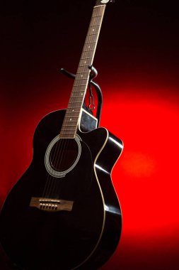 Kırmızı ve siyah gradyan arkaplan ile akustik gitar