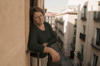 70 'li yaşlardaki olgun bir kadının dramatik bir hayat tarzı. Depresyonda ve üzgün bir şekilde balkonda ağlıyor. Yaşlı kadın depresyonu konseptinde çaresizce acı çekiyor.