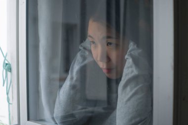 Genç üzgün ve depresif Asyalı Koreli kız. Korkmuş ve endişeli. 19. bölümde karantina altında.