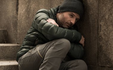 Orta yaşlı, üzgün ve depresif, işsiz bir adamın karanlık ve sinirli şehir portresi. Kirli sokak köşesindeki merdivenlerde oturmuş depresyon sorunu yaşıyor.