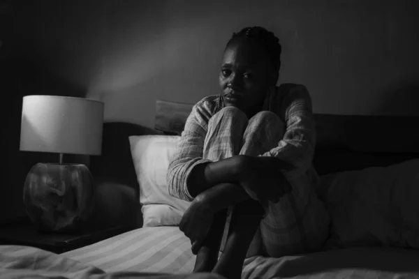 若い病気とうつ状態の黒いアフロ系アメリカ人の女の子の劇的な家の肖像ベッドの上に座って動揺し 夜に眠れない感じ圧倒的な苦しみうつ病と不安の問題 — ストック写真