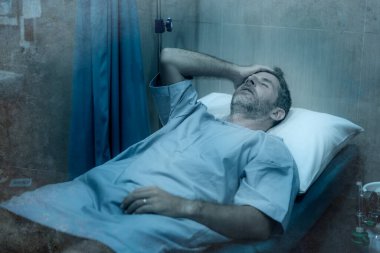 Çekici ve korkmuş bir adamın dramatik sanatsal portresi kovid 19 tarafından enfekte edilmiş - yüz maskeli yetişkin erkek Coronavirus Solunum Bozukluğu tedavisi görüyor