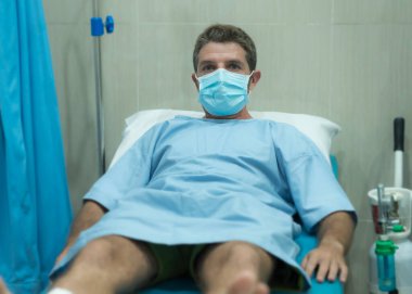 Çekici ve korkmuş bir adamın dramatik sanatsal portresi kovid 19 tarafından enfekte edilmiş - yüz maskeli yetişkin erkek Coronavirus Solunum Bozukluğu tedavisi görüyor