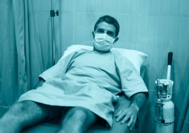Çekici ve korkmuş bir adamın dramatik sanatsal portresi kovid 19 tarafından enfekte edilmiş - yüz maskeli yetişkin erkek Coronavirus Solunum Bozukluğu tedavisi görüyor