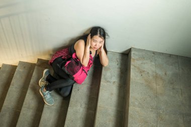 Genç, depresif ve korkmuş Asyalı Çinli kız öğrenci okuldaki zorbalık ve ayrımcılık mağduru üniversite merdivenlerinde işkence gördü ve tacize uğradı.