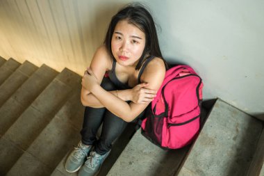 Genç, depresif ve korkmuş Asyalı Çinli kız öğrenci okuldaki zorbalık ve ayrımcılık mağduru üniversite merdivenlerinde işkence gördü ve tacize uğradı.