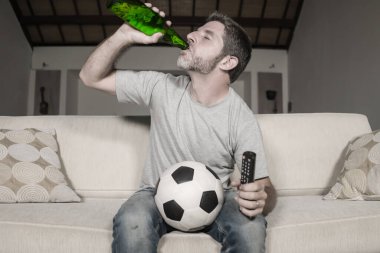 Futbolcu destekçisi televizyondan zevk alıyor. Mutlu ve çekici bir futbol fanatiği. Televizyon seyrediyor.