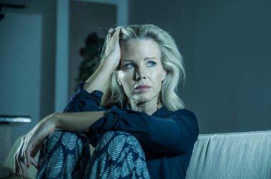Güzel 40 'lı yaşlarda, depresyonda olan bir kadın. Üzgün ve çaresiz sarışın bir kızın dramatik portresi. Kanepede depresyon sorunu.