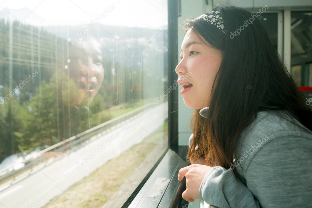 train travel getaway - lifestyle portrait of young happy and beautiful Asian Chinese woman traveling on railway looking through window relaxed and cheerful