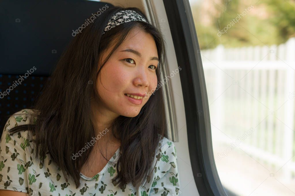 train travel getaway - lifestyle portrait of young happy and beautiful Asian Korean woman traveling on railway looking through window 