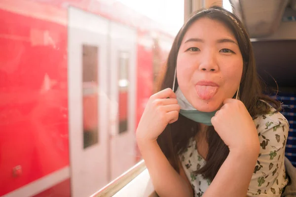 귀여운 아시아 계젊은 마스크를 열차안을 여행하며 휴가를 즐기고 모습의 열차안을 — 스톡 사진