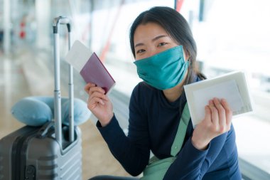 19 kez uçan Asyalı bir kadın. Mutlu ve güzel bir Koreli kız. Havaalanı kapısında tatil için bekliyor.