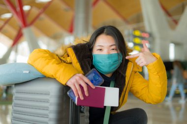 19 kez uçan Asyalı bir kadın. Yüzü maskeli, sarı ceketli, mutlu ve güzel bir Japon kızın hayat tarzı portresi. Tatil gezisi için havaalanı salonunda bekliyor. 