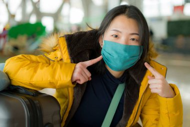 19 kez uçan Asyalı bir kadın. Yüzü maskeli, sarı ceketli, mutlu ve güzel bir Koreli kızın hayat tarzı portresi. 