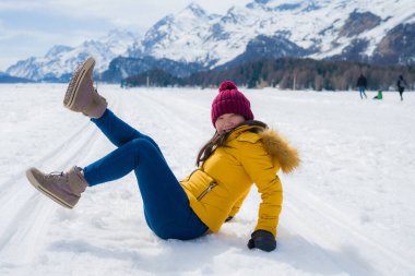 Karda kış tatili - genç mutlu ve güzel Asyalı Çinli kızın yaşam tarzı portresi İsviçre Alplerindeki karlı dağlarda donmuş gölde eğleniyor.