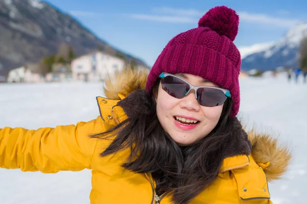스위스 알프스의 눈덮인 얼어붙은 호수에서 장난기있게 아름다운 아시아 소녀의 — 스톡 사진