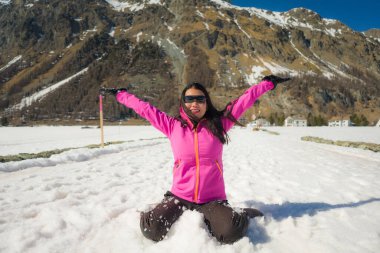 Noel tatili boyunca güzel dağlarda kar üzerinde oynayıp eğlenen genç mutlu ve çekici Asyalı kadının açık hava yaşam tarzı portresi.