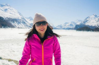 Noel tatili boyunca güzel dağlarda kar üzerinde eğlenen genç, mutlu ve çekici Asyalı kadının açık hava yaşam tarzı portresi.