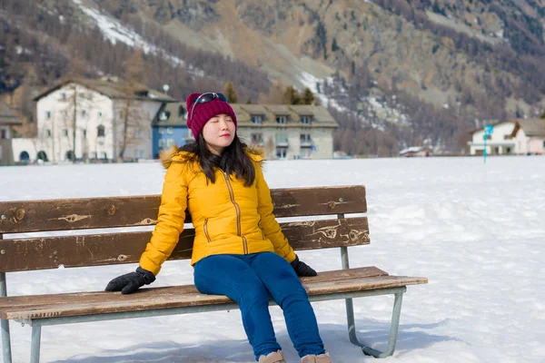 스위스 알프스 산맥에서 눈덮인 경치를 즐기며 벤치에 아름다운 아시아 겨울철의 — 스톡 사진