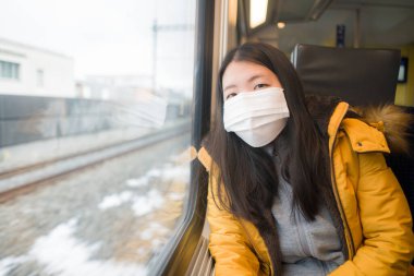 Korunmak için maske takmış güzel ve düşünceli Asyalı bir kadının hayat tarzı portresi.