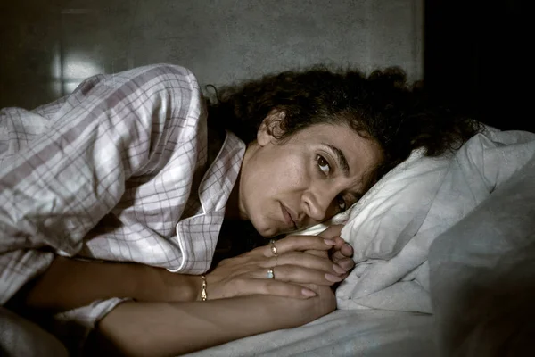うつ病と眠れないラテン語の女性の暗いとエッジの肖像は心配して横になり 不眠症やうつ病の問題に苦しんで夜にベッドで目覚め — ストック写真