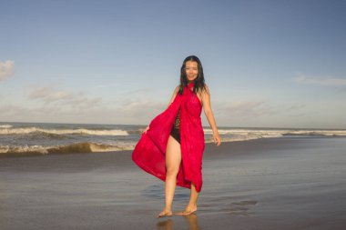 Genç, mutlu ve çekici Asyalı bir kadının yaz portresi. Geleneksel giysili, güzel plajda, tropik adaya tatil gezisinin tadını çıkarıyor. 