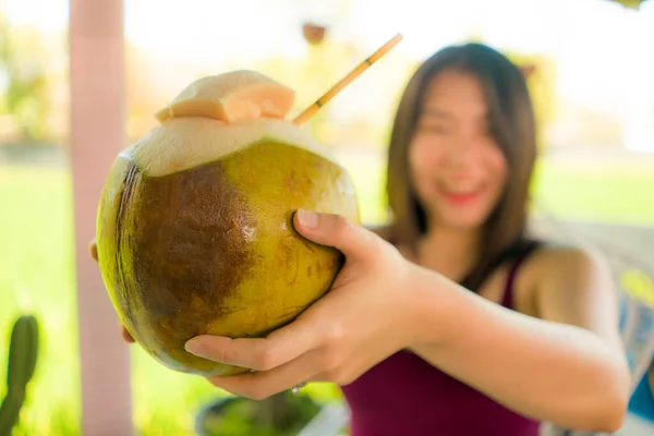 若いココナッツを持つ焦点の浅い深さの女性バリの夏休みの間にココナッツ水を楽しむ幸せと陽気な笑顔屋外 — ストック写真