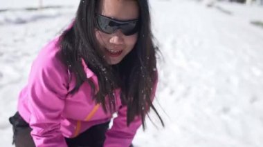 Genç Koreli kadın muhteşem karlı manzara manzarasının keyfini çıkarıyor. Mutlu ve güzel Asyalı kız donmuş gölde kış karıyla oynuyor ve İsviçre Alpleri 'nde tatil yaparken dağlarla oynuyor.