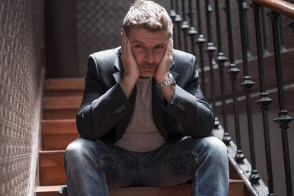 失業と離婚 階段の上に屋内に座っている40代の悲しいと落ち込んでいる男の劇的なライフスタイルの肖像思慮深く 心配しているうつ病の問題 — ストック写真