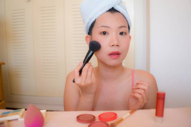 Asyalı kadın ve makyaj. Havluyla sarılıp banyodaki aynaya güzellik ve moda konseptiyle bakan mutlu ve güzel Çinli kız.