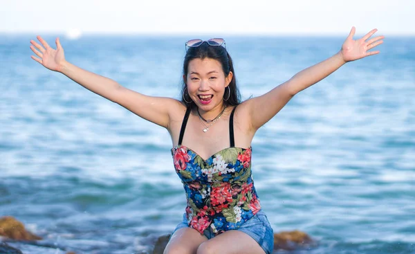 해변의 절벽에서 느긋하고 명랑하게 여행을 즐기고 아름답고 아름다운 아시아 여성의 — 스톡 사진