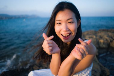 young happy and beautiful Asian woman by the sea - Attractive Korean girl cheerful enjoying relaxed summer holidays at tropical island in travel and lifestyle concept