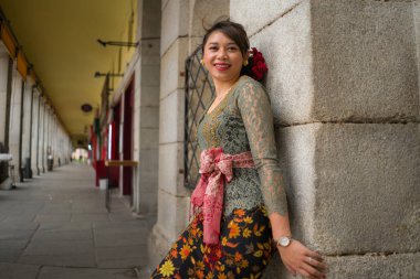 Genç ve güzel Asyalı kadın geleneksel Balili kebaya elbisesi giyiyor - Bali elbiseli Endonezyalı kız Avrupa 'da tatil gezileri sırasında sokakta yürüyor