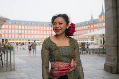 Genç ve güzel Asyalı kadın geleneksel Balili kebaya elbisesi giyiyor - Bali elbiseli Endonezyalı kız Avrupa 'da tatil gezileri sırasında sokakta yürüyor