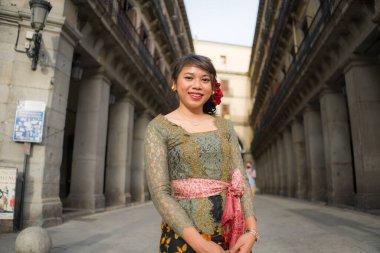 Genç ve güzel Asyalı kadın geleneksel Balili kebaya elbisesi giyiyor - Bali elbiseli Endonezyalı kız Avrupa 'da tatil gezileri sırasında sokakta yürüyor