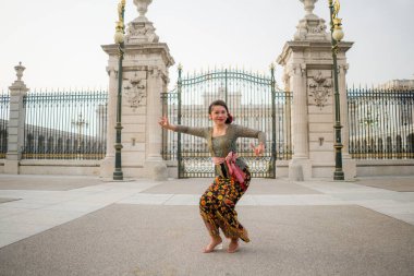 Bali 'li genç mutlu Endonezyalı kadın Avrupa' da tatil yapıyor. Çekici ve neşeli Balili turist kız şehirde geleneksel kıyafetleriyle turneye çıkıyor ve tatilin tadını çıkarıyor.