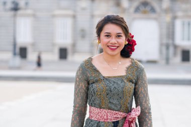 Bali 'li genç mutlu Endonezyalı kadın Avrupa' da tatil yapıyor. Güzel ve neşeli Balili turist kız geleneksel kıyafetleriyle şehirde turneye çıkıyor.