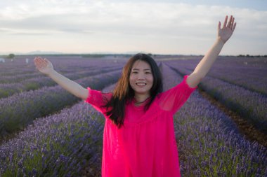Lavanta çiçekleri tarlasında genç Asyalı bir kadın. Mutlu ve güzel bir Japon kızı. Tatlı, mavi yaz elbisesi içinde.