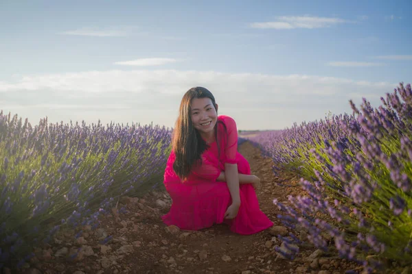 Lavanta çiçekleri tarlasında genç Asyalı bir kadın. Mutlu ve güzel bir Japon kızı. Tatlı, mavi yaz elbisesi içinde.