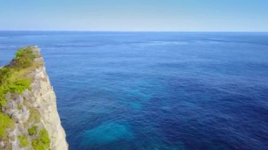 Endonezya 'nın Bali adasındaki tropikal cennet plajında uçan kaya oluşumunun üzerindeki insansız hava aracından güzel bir geri çekilme. Egzotik seyahat konsepti.